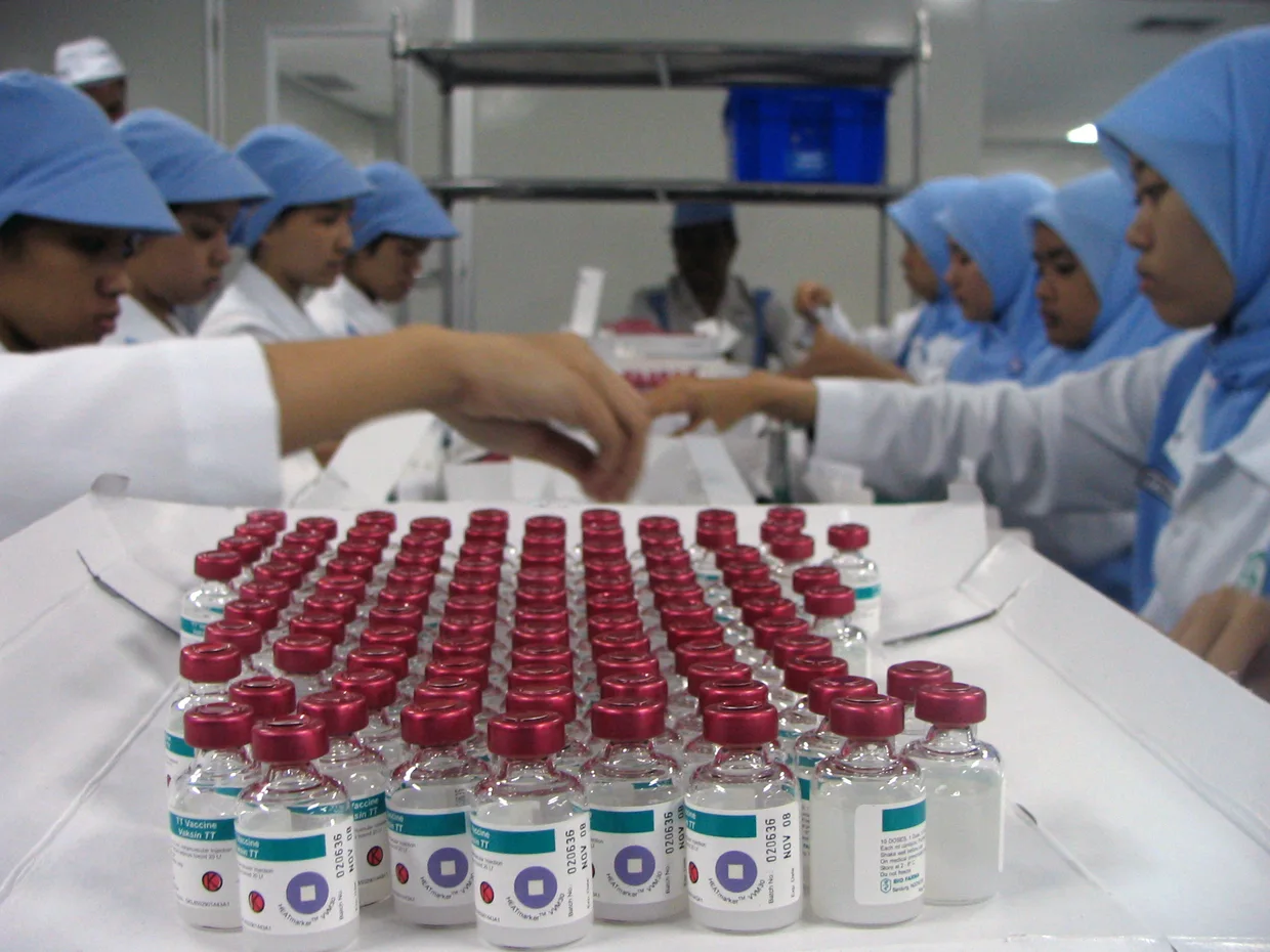 Lab workers in the Bandung BioFarma facility in Indonesia examine vials that have vaccine vial monitor technology incorporated into their labels.   BioFarma, Bandung, Indonesia, February 2017